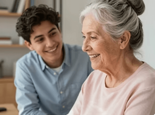 An older adult smiling with a younger family member nearby.